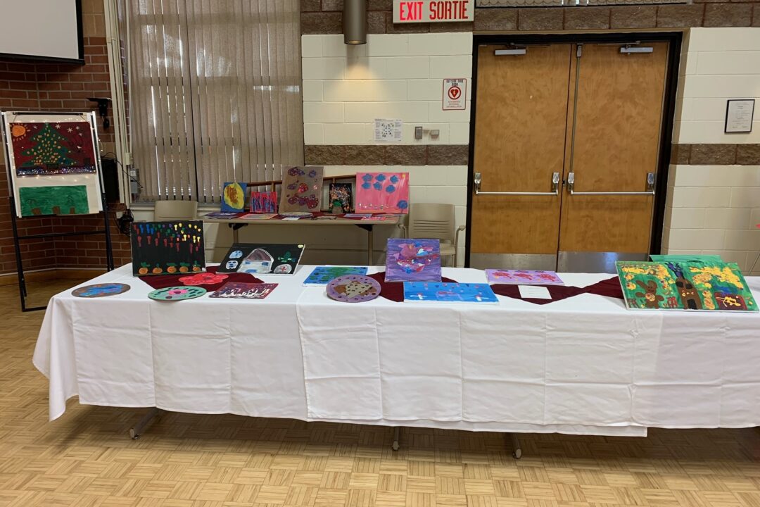 Artwork display on a table at a school event.