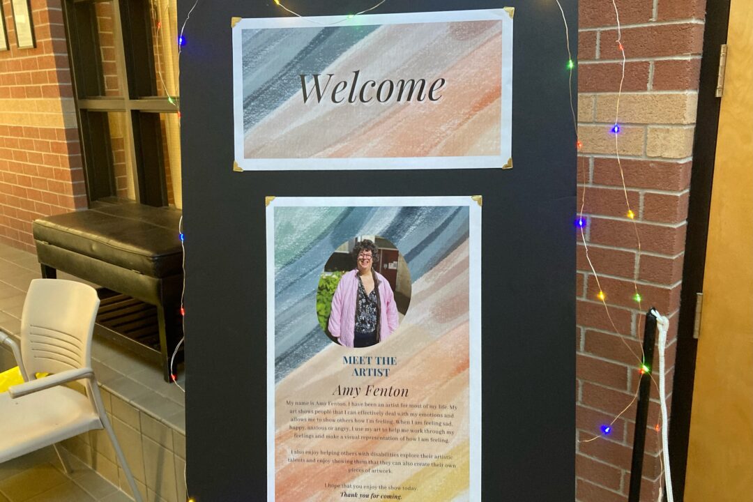 A decorated welcome board with a photo and introductory information about a person named amy fenton.